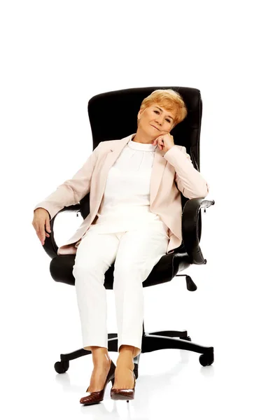 肘掛け椅子に座って心配している高齢者ビジネス女性 — ストック写真