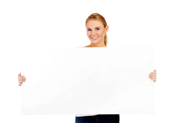 Happy young woman with blank billboard — Stock Photo, Image