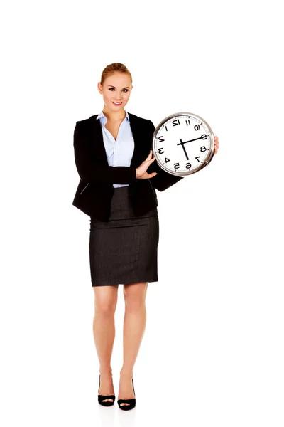 Sonriente joven mujer de negocios sosteniendo reloj de oficina —  Fotos de Stock