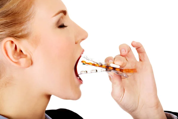 Giovane donna d'affari che cerca di mangiare blister di pillole — Foto Stock