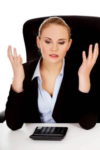 Nervös affärskvinna räkna med miniräknare beahind skrivbordet — Stockfoto