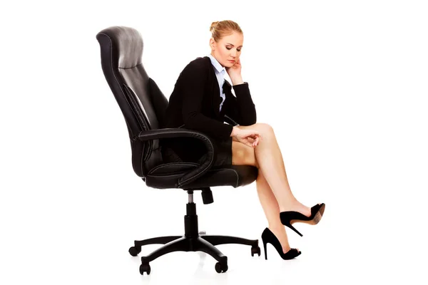 Zmęczona lub zaniepokojona kobieta biznesu siedząca na fotelu — Zdjęcie stockowe