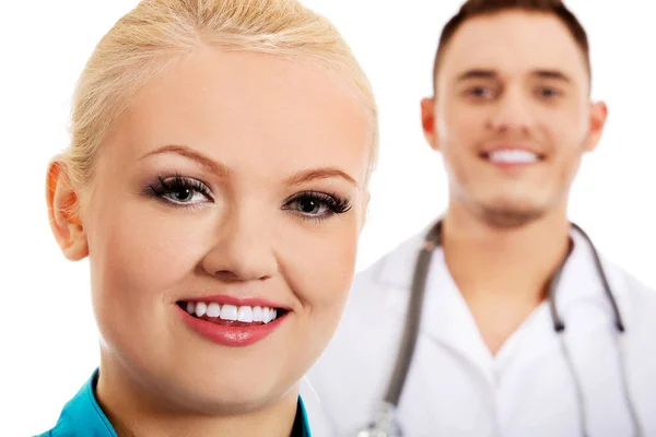 Jonge vrouwelijke en mannelijke artsen glimlach — Stockfoto