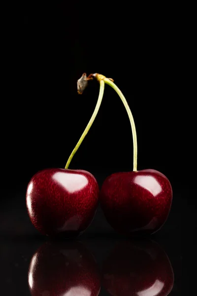 Dos jugosas cerezas frescas sobre fondo negro — Foto de Stock