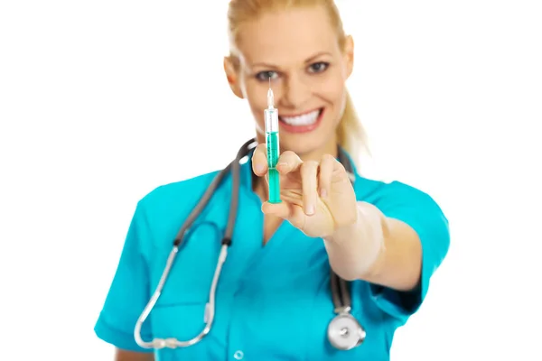 Médico o enfermera sonriente con estetoscopio que sostiene la jeringa —  Fotos de Stock