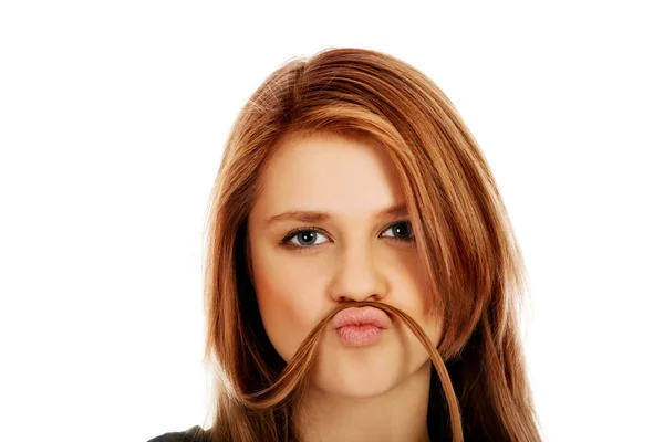 Happy teenage woman making moustache from hair — Stock Photo, Image