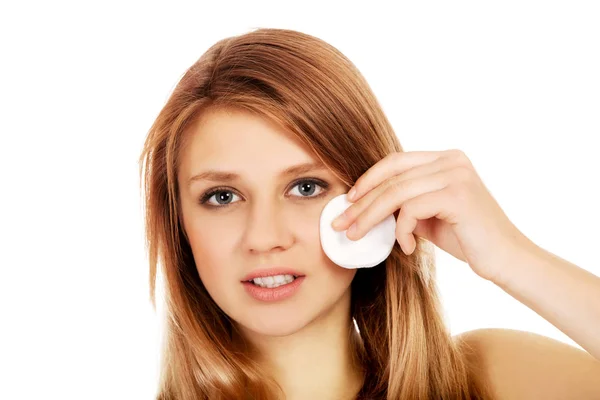 Teen woman removing makeup with cotton pad — Stock Photo, Image
