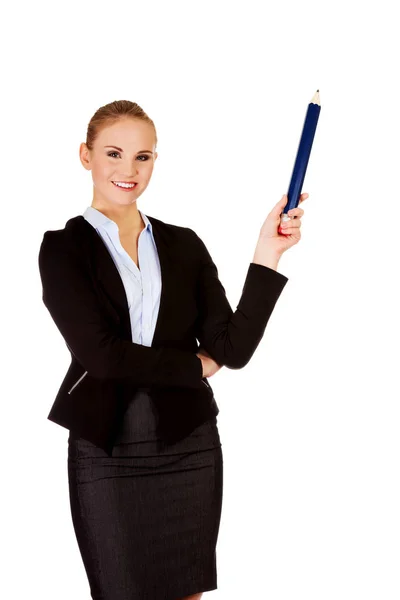 Mujer de negocios apuntando para copyspace o algo con la pluma enorme —  Fotos de Stock