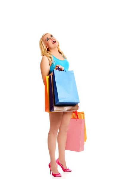 Jovem chocada segurando sacos de compras — Fotografia de Stock