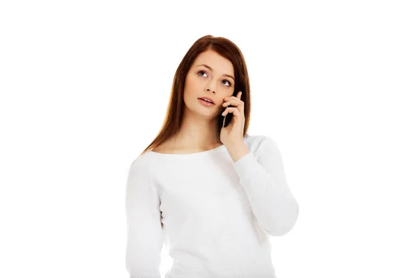 Mulher adolescente pensativo falando através de um telefone móvel — Fotografia de Stock