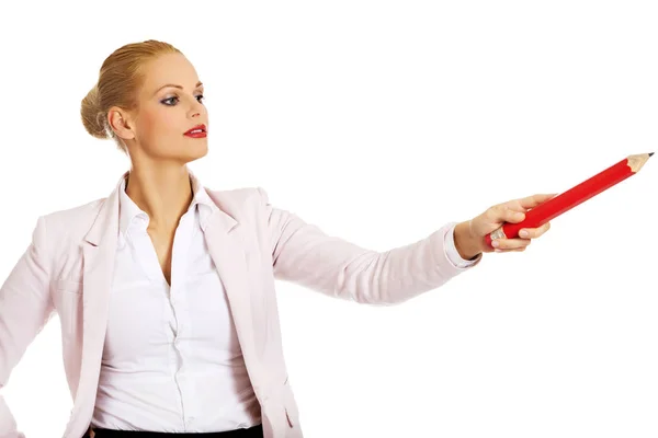 Business woman pointing for copyspace or something with huge pen — Stock Photo, Image