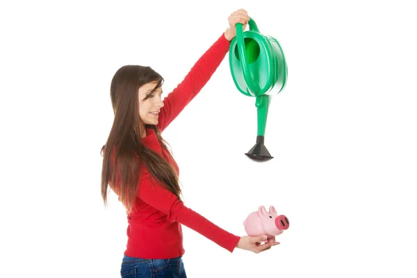 Woman watering piggybank. — Stock Photo, Image