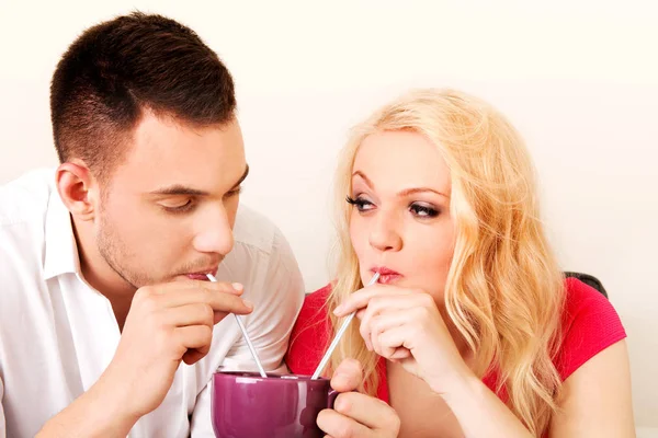 Cute couple drinking from one cup — Stock Photo, Image