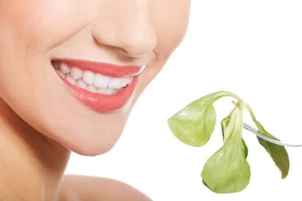 Hermosa mujer caucásica comiendo luttce verde fresco de un tazón — Foto de Stock