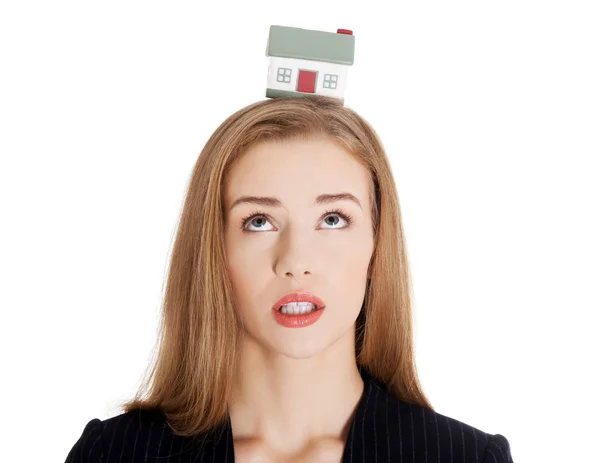 Mooie Kaukasische zakenvrouw met huis model op hoofd. — Stockfoto