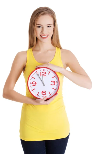 Mulher casual caucasiana bonita segurando relógio vermelho . — Fotografia de Stock