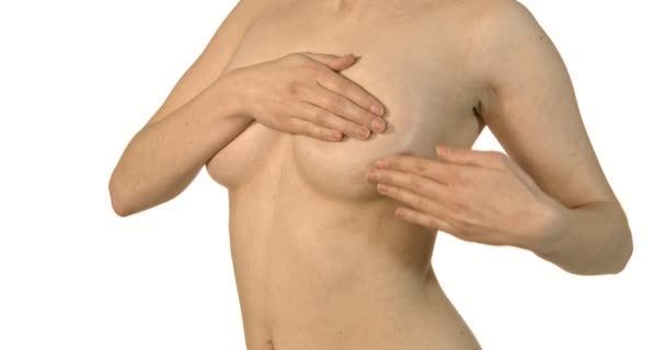 Gros plan de jeune femme torse nu examinant ses seins. — Video