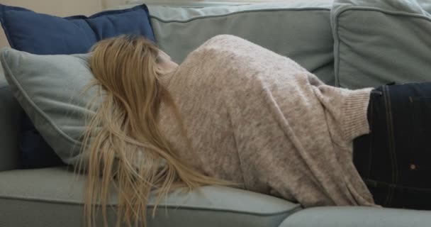 Junge schläfrige Frau fällt zu Hause auf Sofa um. — Stockvideo