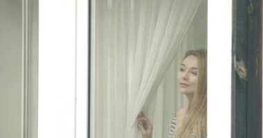 güzel genç kadın pencereden arıyor.