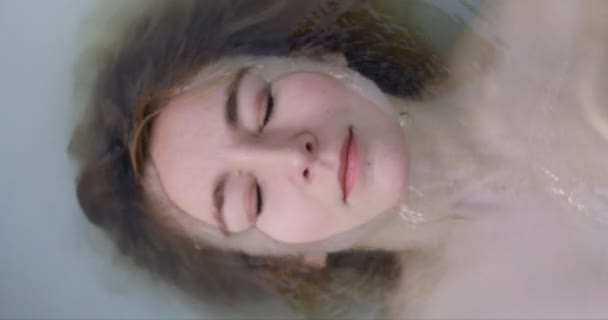 Κοντινό πλάνο του μια όμορφη γυναίκα κάτω από το νερό — Αρχείο Βίντεο