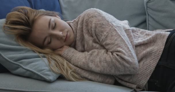 Jovem mulher sonolenta caindo no sofá em casa . — Vídeo de Stock