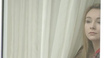 güzel genç kadın pencereden arıyor.