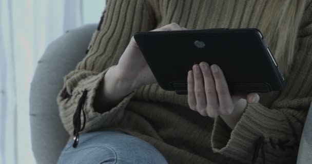 Frau benutzt ihren Tablet-PC auf der heimischen Couch im Wohnzimmer — Stockvideo