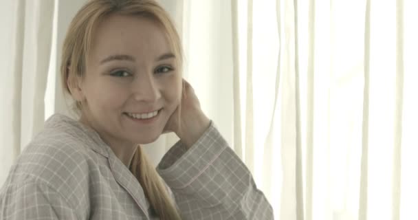 Hermosa mujer sonriente mirando a la cámara en casa en la sala de estar — Vídeos de Stock