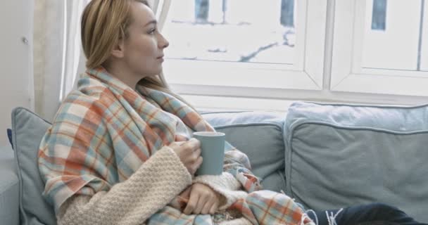 Portret van een vrouw thuis ontspannen met een kopje thee — Stockvideo