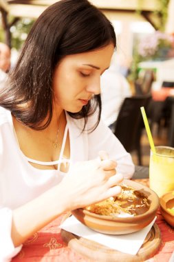 Genç kadın restoranda yiyor.