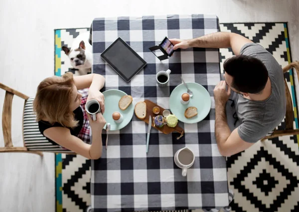 Любящая пара, сидящая за кухонным столом, завтракающая вместе — стоковое фото
