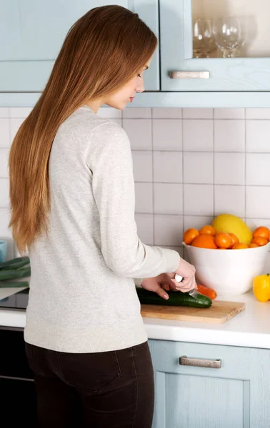 Jovem mulher cortando legumes — Fotografia de Stock