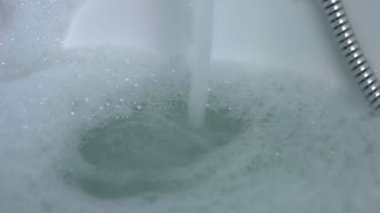 Su küvete düşüyor.