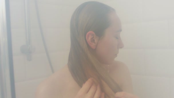 Голая женщина принимает горячий душ — стоковое видео