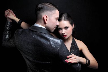 Profesyonel dansçılar koyu arka plan üzerinde tutkulu tango dans çekici çift
