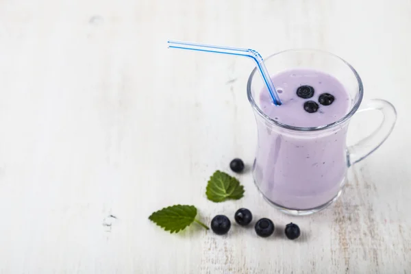 Smoothie com mirtilos em uma mesa de madeira — Fotografia de Stock