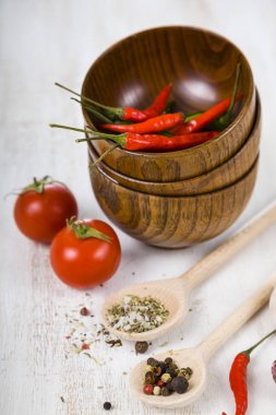Taze domates ve bir ahşap kase ve kaşık sıcak biber