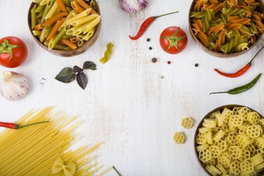 Pişmemiş makarna ve ahşap masa içinde baharatlar. Makarna ve malzemeler: chi