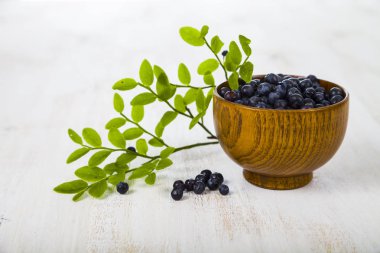 Yaban mersini bir tabloda bir ahşap kase