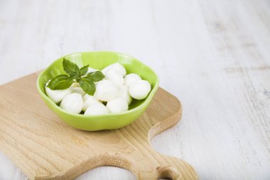 Mozzarella ahşap bir masa üzerinde yeşil bir tabak içinde. Lezzetli taze c
