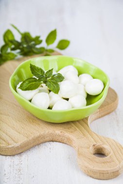 Mozzarella ahşap bir masa üzerinde yeşil bir tabak içinde. Lezzetli taze c