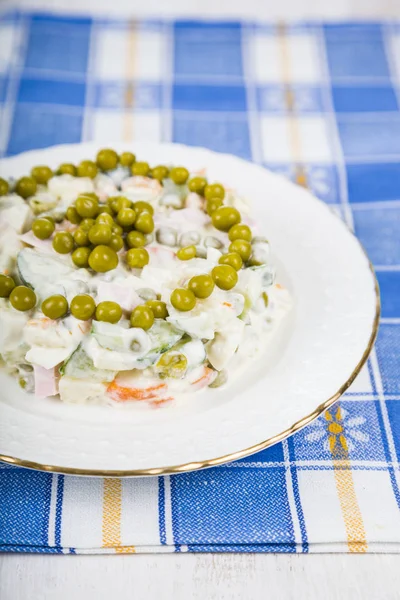 Köstlicher Salat auf einem Holztisch mit blauem Tuch. Salatolivi — Stockfoto