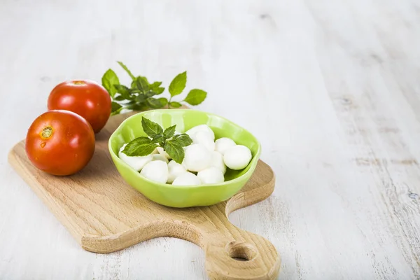 Mozzarella v zelené desky na dřevěný stůl. Kuličky mozzarelly — Stock fotografie