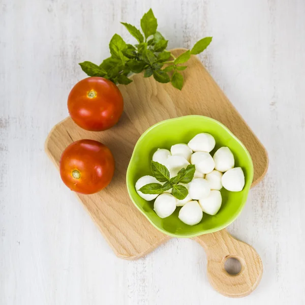 Mozzarella em uma chapa verde em uma mesa de madeira. Bolas de mussarela — Fotografia de Stock