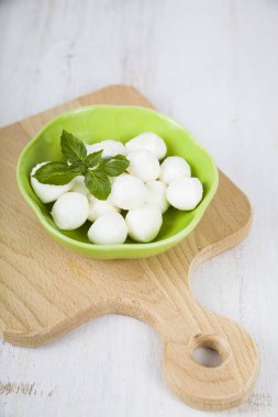 Mozzarella ahşap bir masa üzerinde yeşil bir tabak içinde. Lezzetli taze c