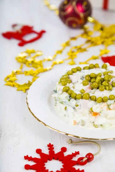 Olivensalat auf einem weihnachtlich dekorierten Tisch. Weihnachten — Stockfoto