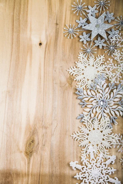 Ασημένια νιφάδες χιονιού σε ένα ξύλινο τραπέζι. Κλείστε διακοσμήσεις Χριστουγέννων — Φωτογραφία Αρχείου