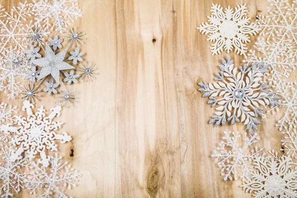 Flocos de neve de prata em uma mesa de madeira. Decorações de Natal perto — Fotografia de Stock