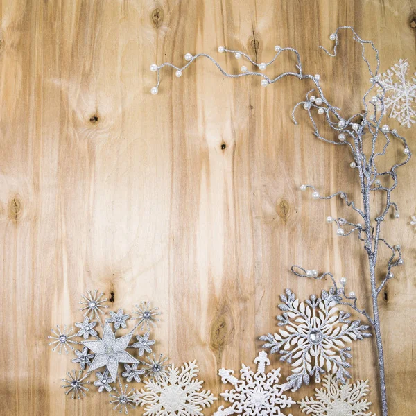 Silberne Schneeflocken und dekorativer Zweig auf einem Holztisch. Weihnachten — Stockfoto