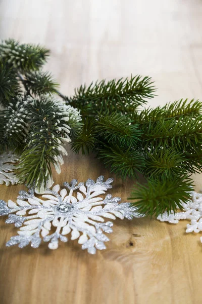 Copos de nieve de plata y ramas de abeto en una mesa de madera. Navidad —  Fotos de Stock